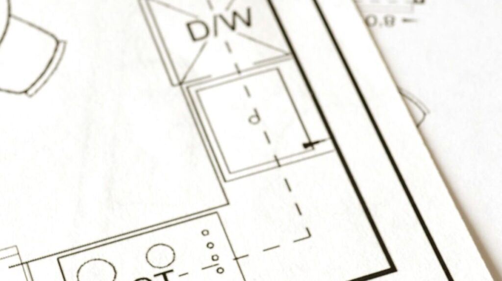 Close-up view of an architectural floor plan on paper showcasing detailed room layouts and measurements.