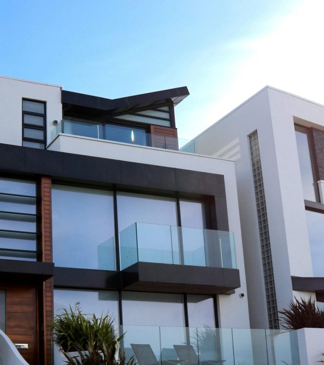 Contemporary luxury home with glass balconies in Poole, UK, showcasing modern architectural design.